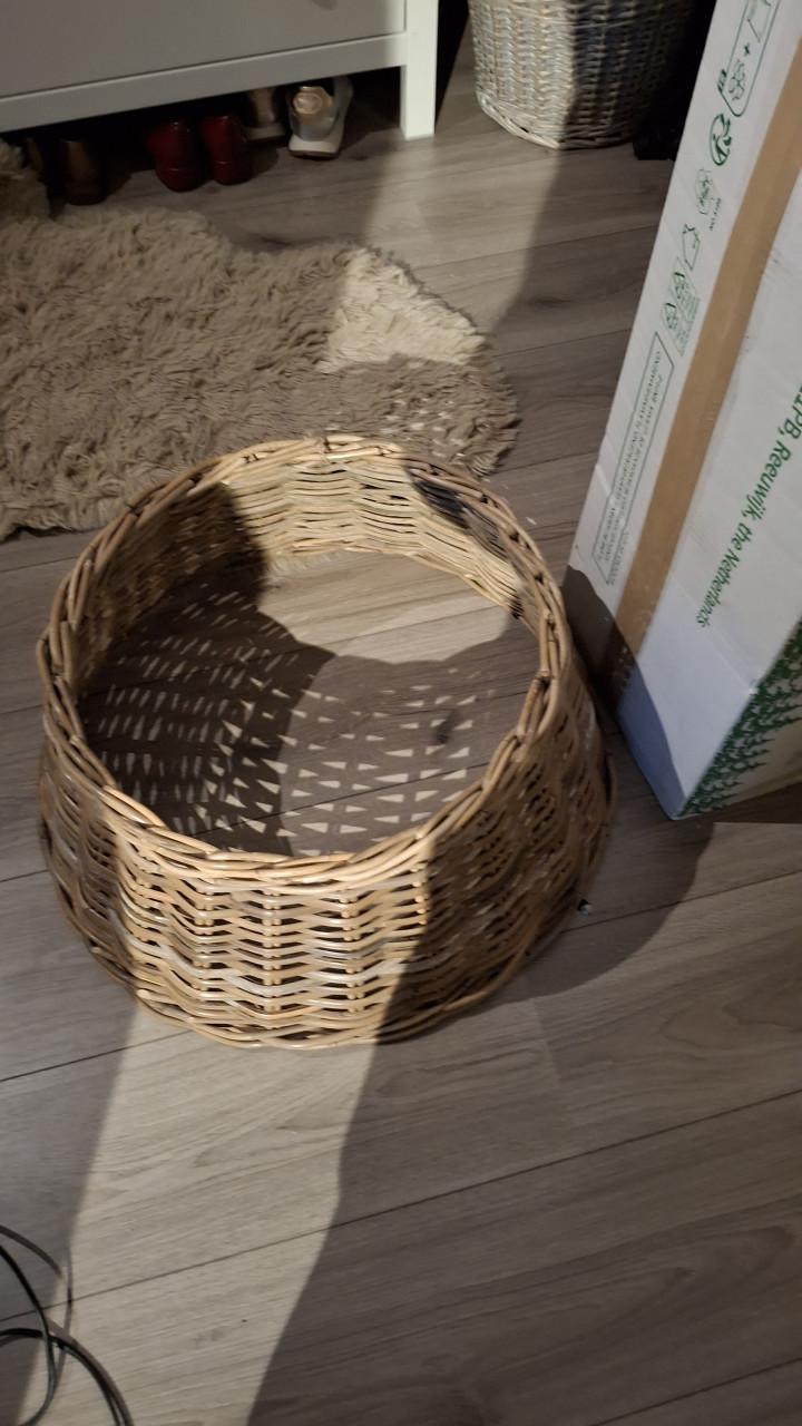 Smalle besneeuwde kerstboom met mand