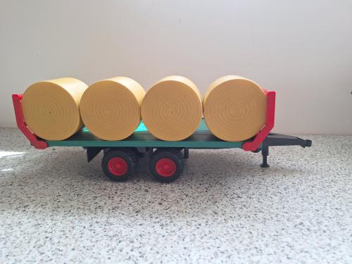 Bruder platte kar met ronde balen.