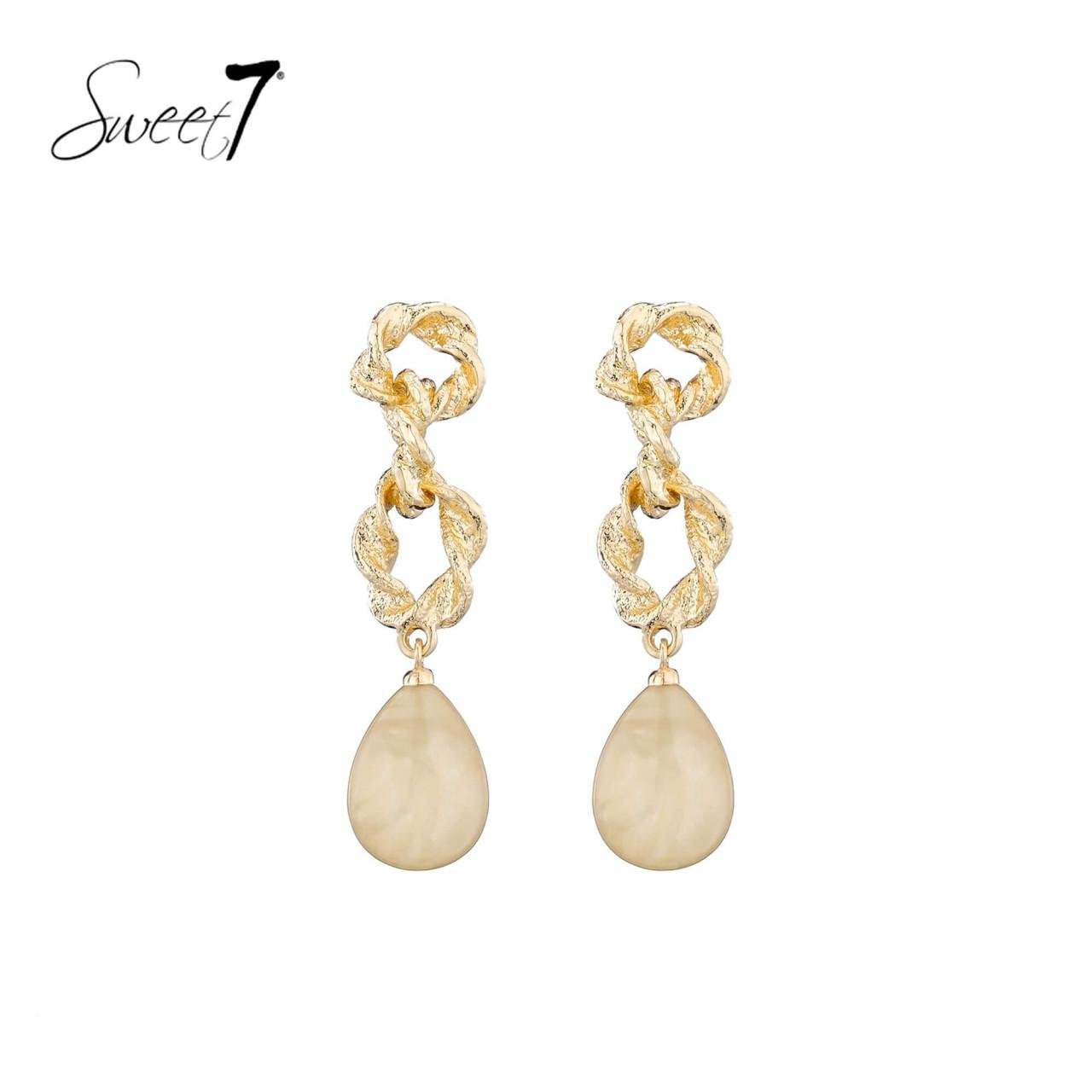 Oorbellen met goudkleurige gedraaide schakels en een beige hanger