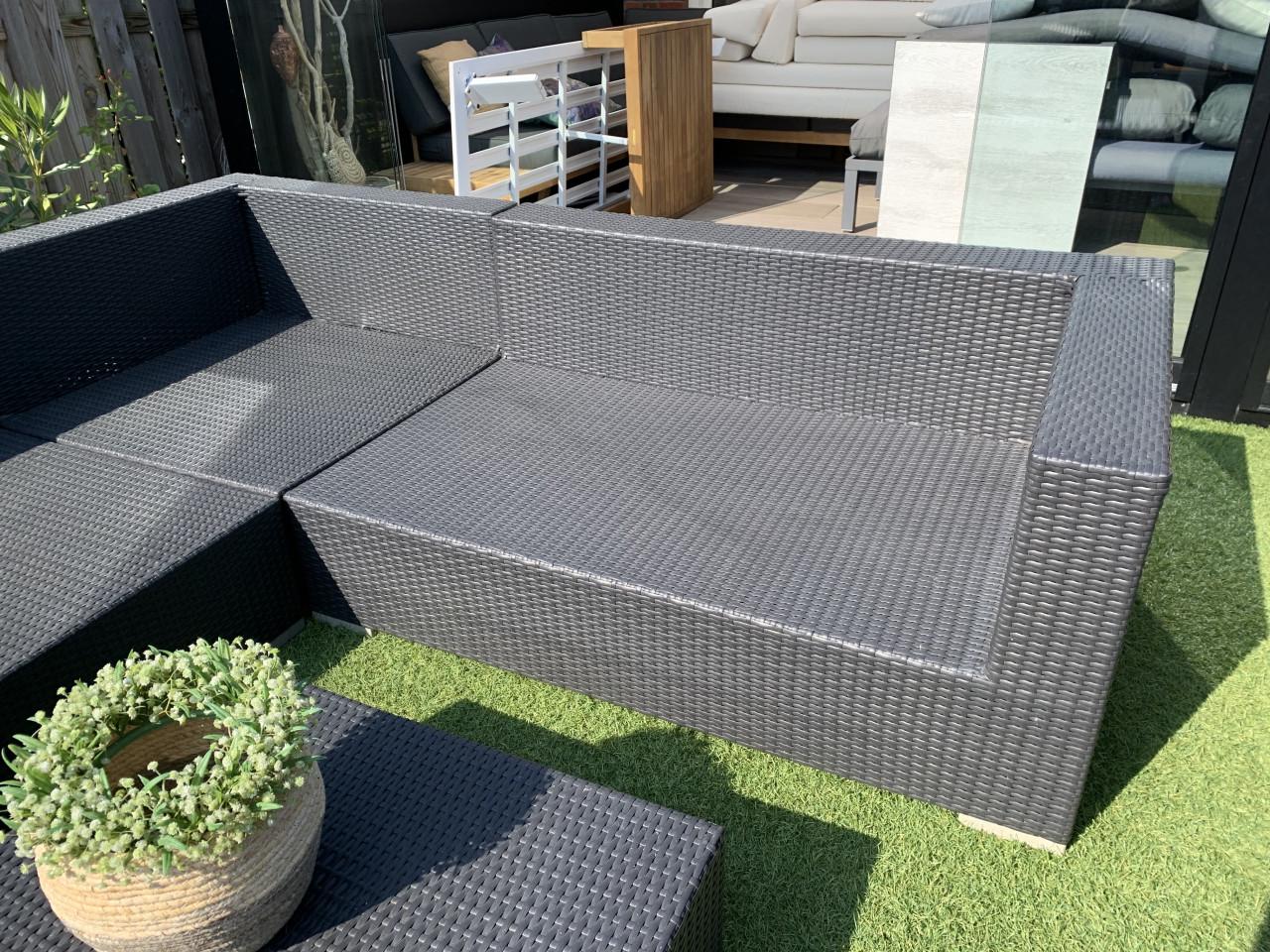 Wicker loungeset zwart met kussens en tafel.