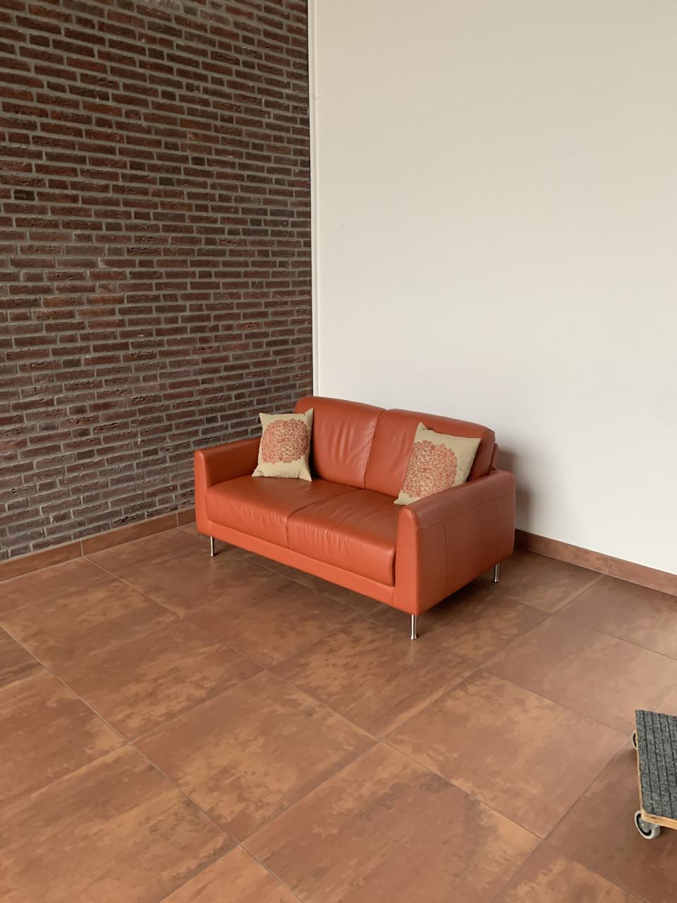 Leuk oranje kleurig bankje met twee kussens