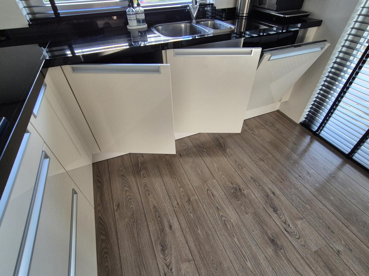 Hoekkeuken hoogglans met zwart granieten blad.