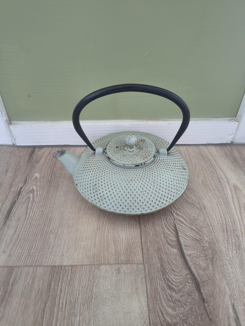 Prachtige groene gietijzeren theepot met hengsel en deksel.