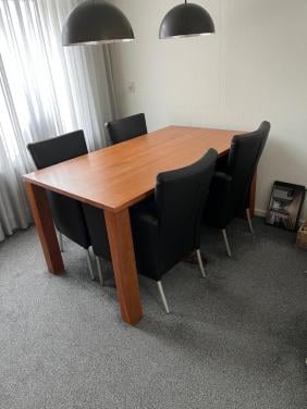 Eettafel met zwart lederen stoelen