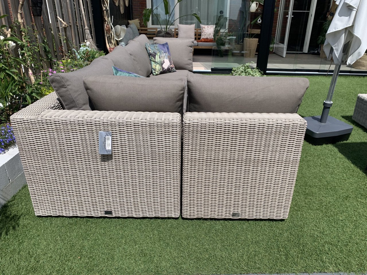 Rieten loungeset met kussens en tafel.