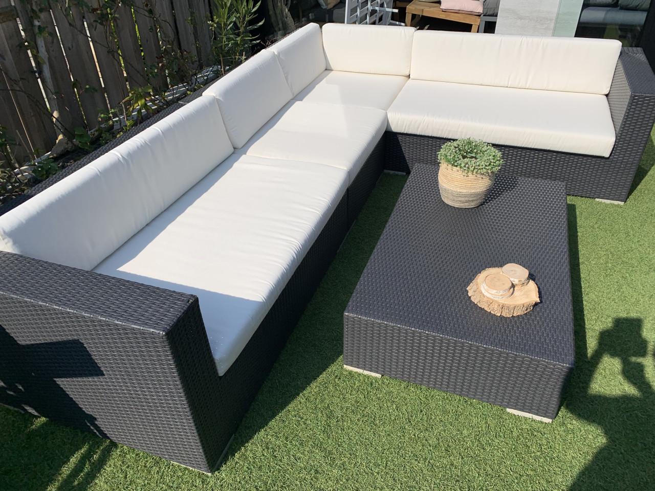 Wicker loungeset zwart met kussens en tafel.