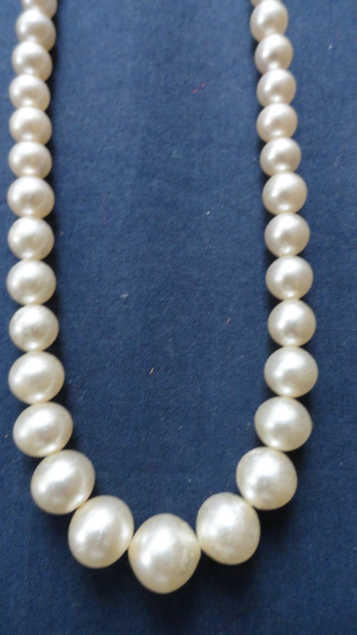 Ketting met van klein naar groot (nep) parels. Met fraai slotje.