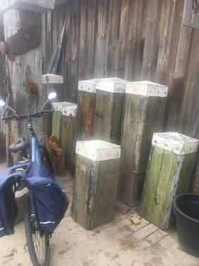 Echte hardhouten meerpalen met metalen kap dikte plusminus 40 cm dik