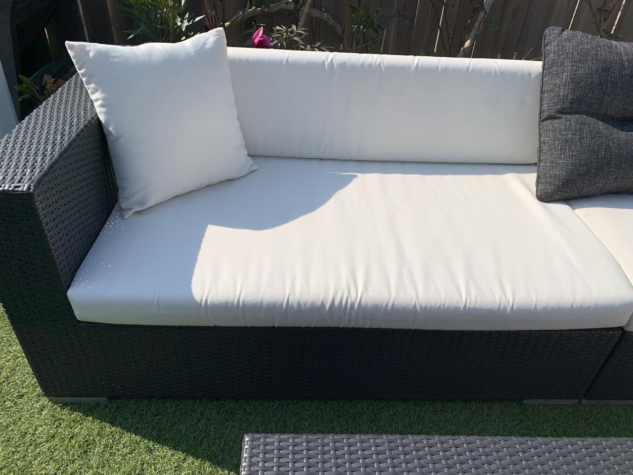 Wicker loungeset zwart met kussens en tafel.