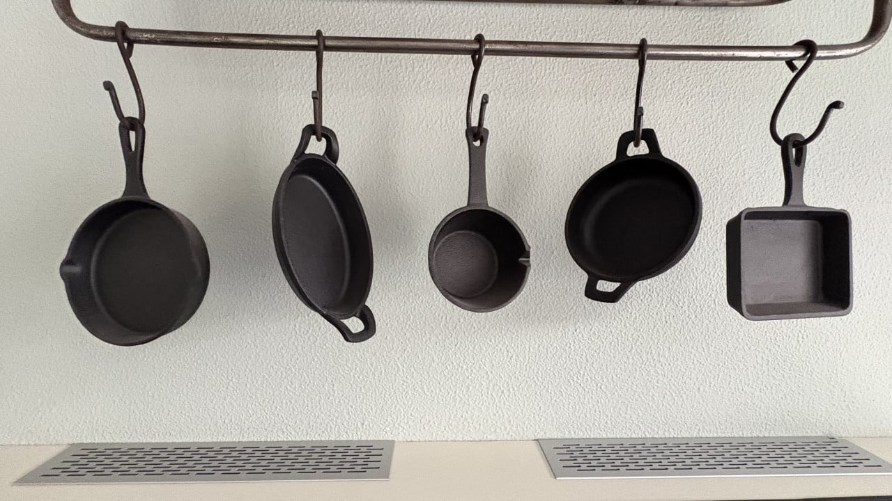 Metalen bakkersrek met gietijzeren pannetjes