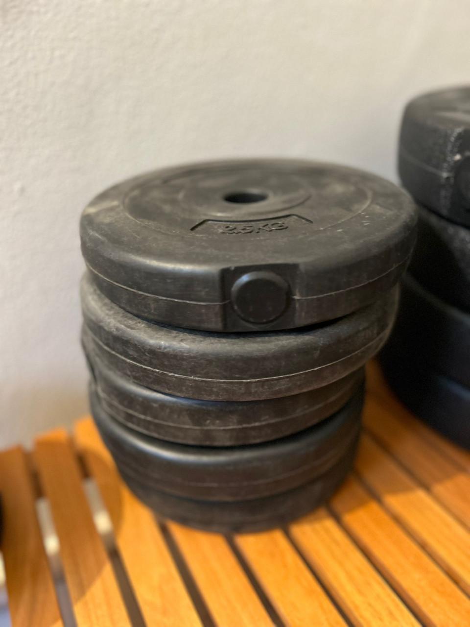 Halterbank met haltergewichten, rubber tegels en magnesium