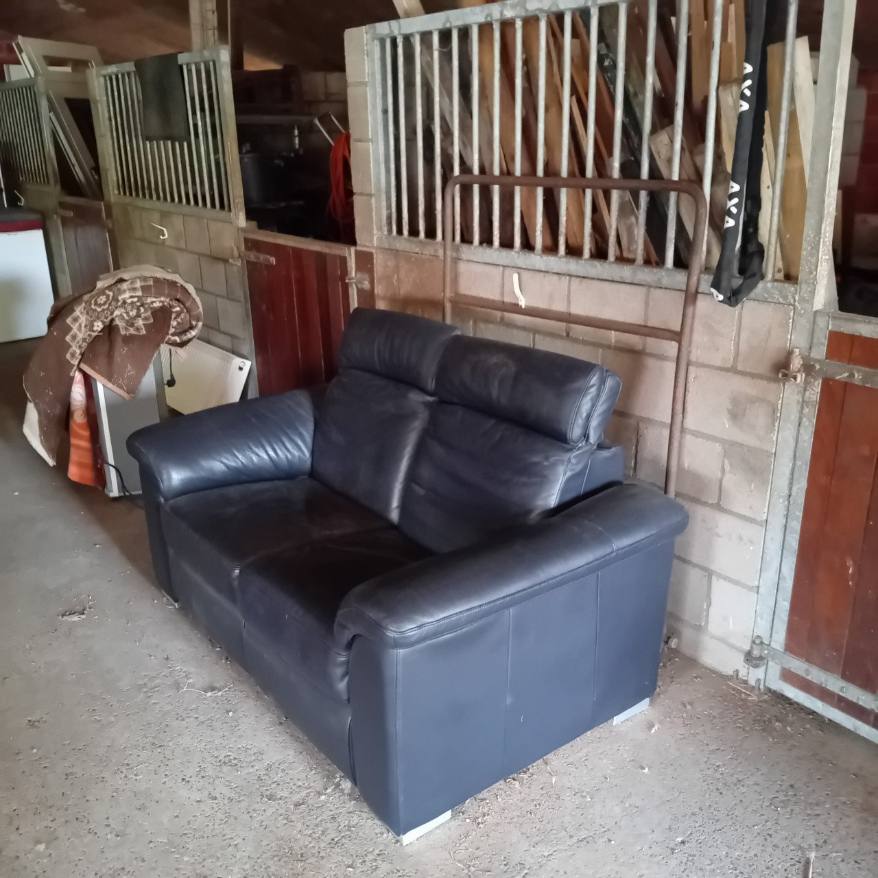 Te koop een donkerblauw leren 2-zitsbank met verstelbare hoofdeinden
