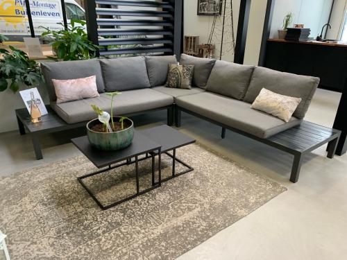 Alminium zwart loungeset, grijze kussens, en 2 salontafels.