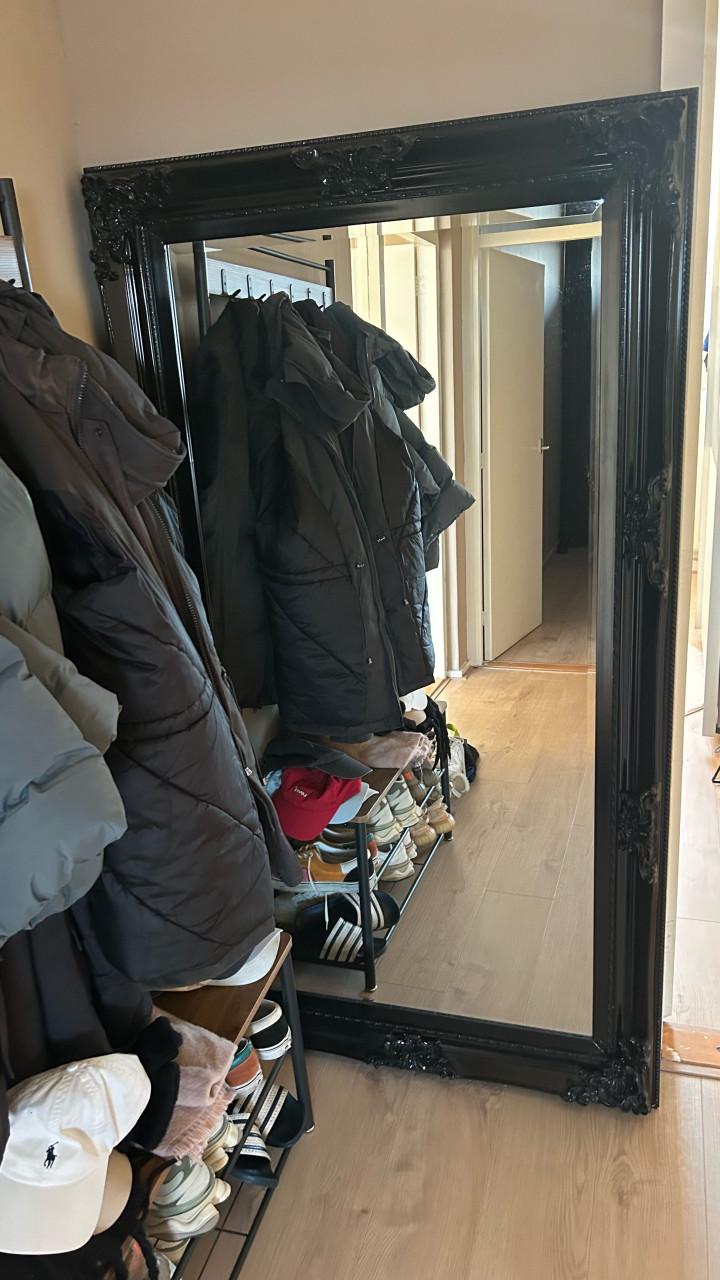 Grote spiegel met zwarte houten sierlijst