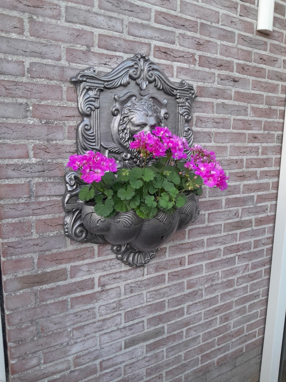 Antieke muurplaat met bloembak