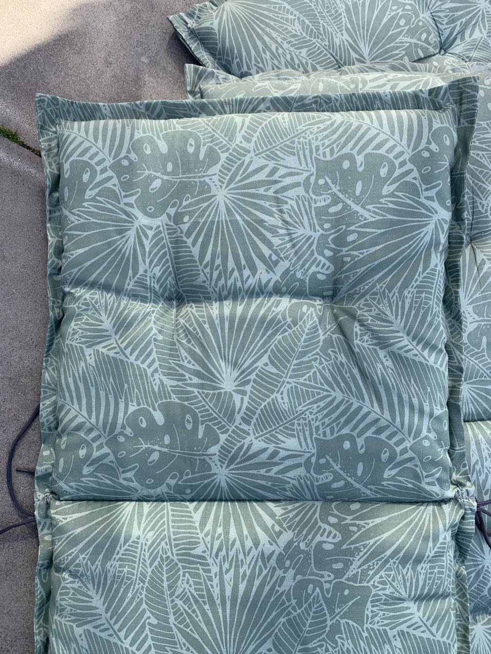 Vier  tuinstoelkussens met een groene bladprint. Met hoes