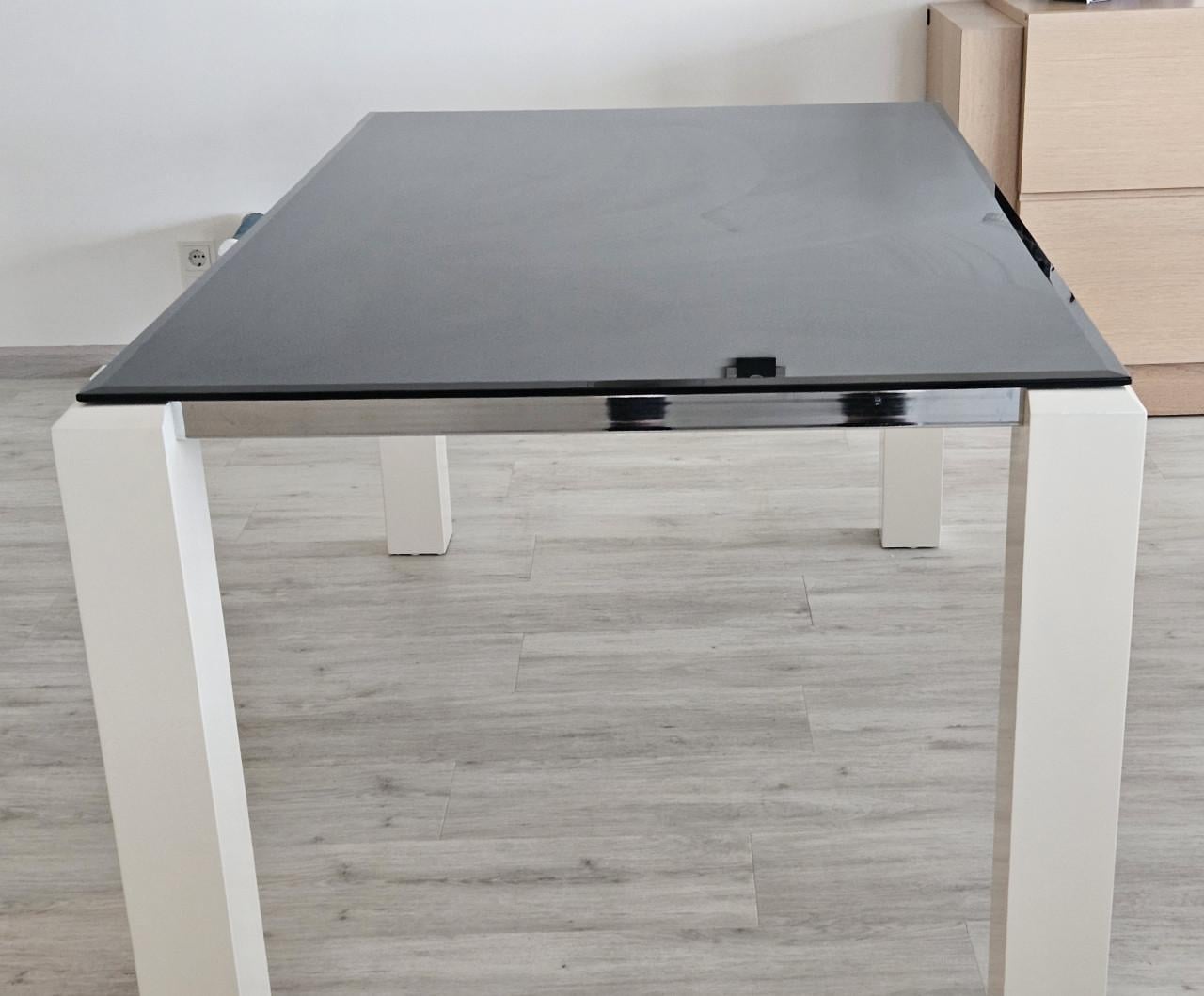 Eettafel van zwart rookglas met witte poten