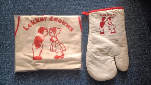 Schort + ovenwand met tekst: Lekker Zeeuws. Nieuw.