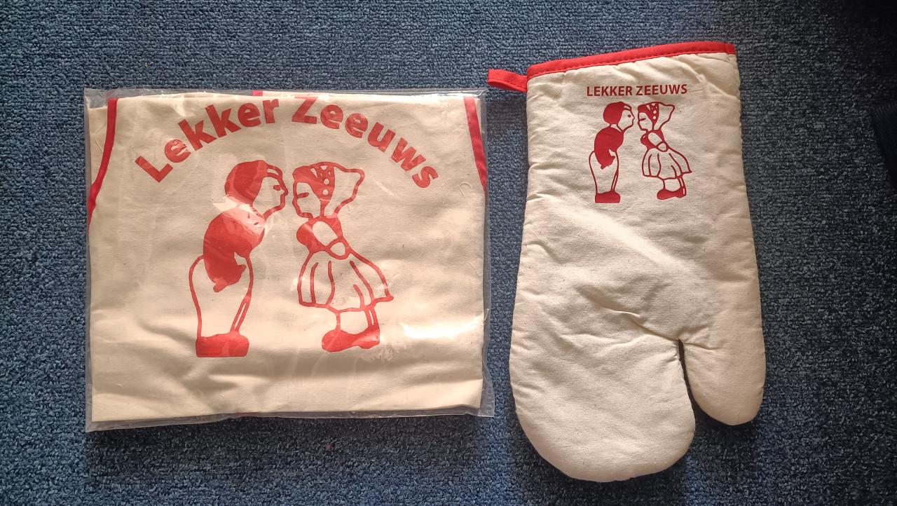 Schort + ovenwand met tekst: Lekker Zeeuws. Nieuw.