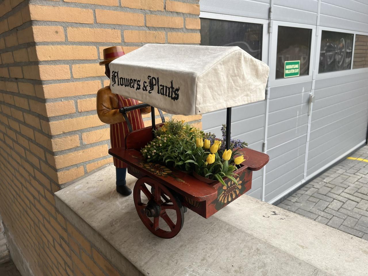 Miniatuur bloemkarretje met pop