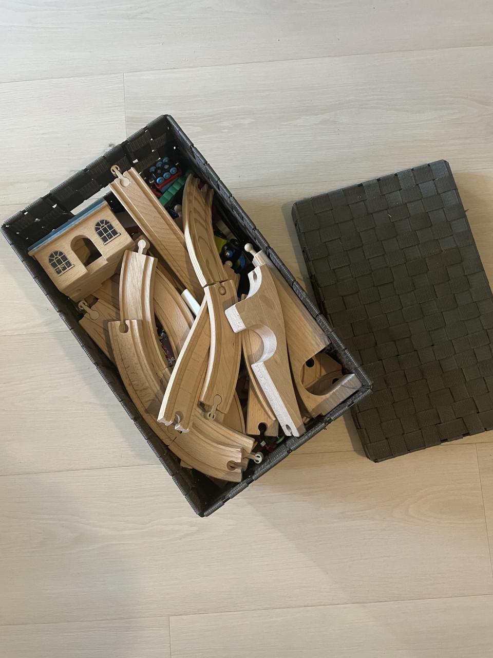 Grote mand vol houten treinrails en toebehoren