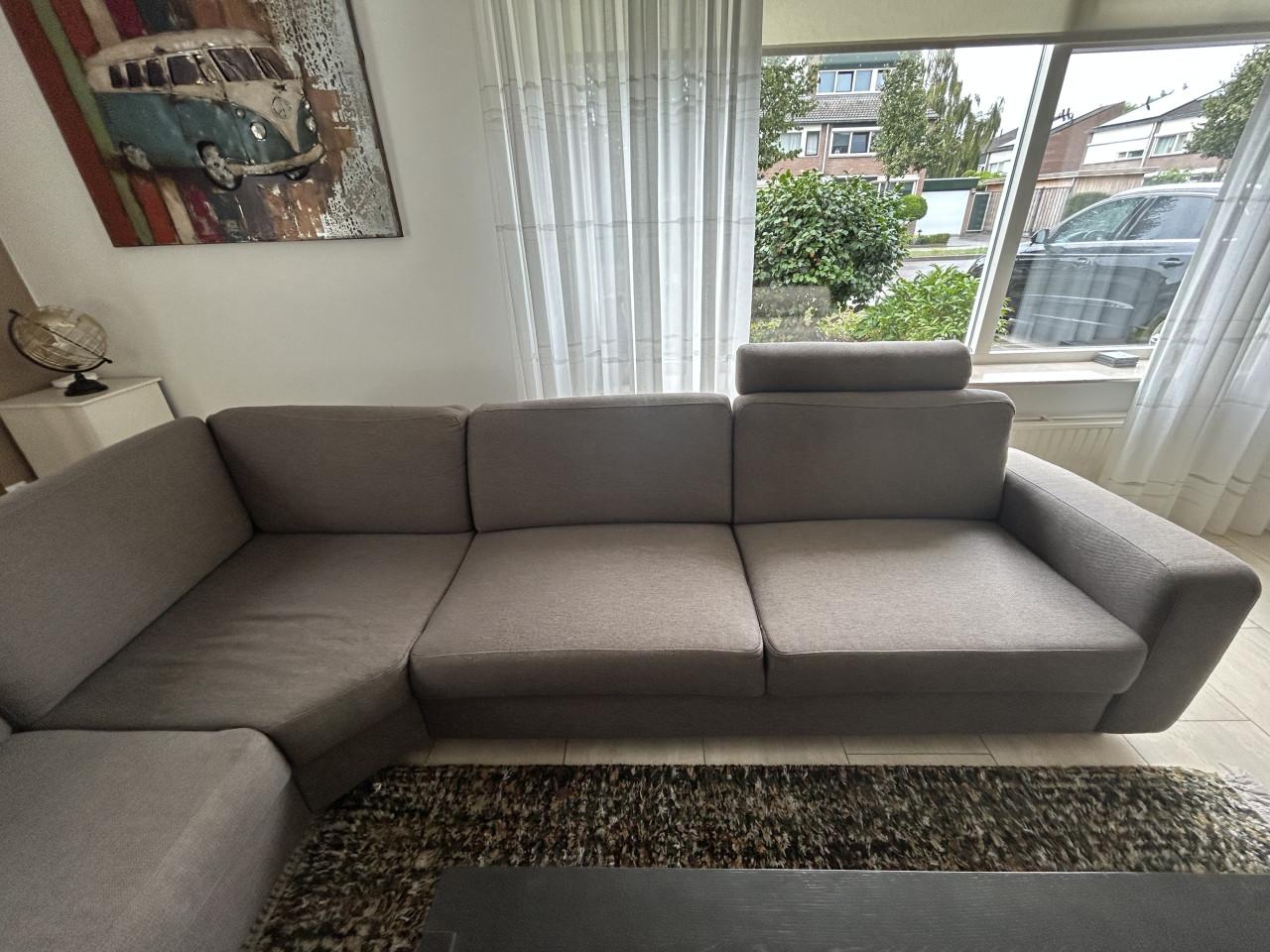 Mooie hoekbank met loungegedeelte en hoofdsteunen in Taupe kleur.