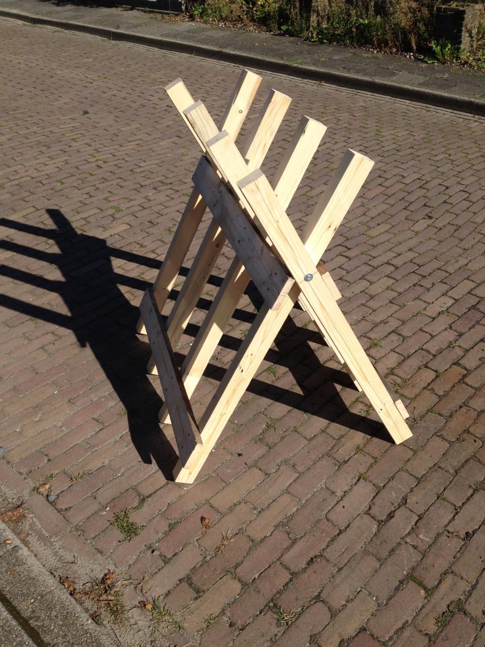 Veel haardhout doorzagen met kettingzaag en robuste stabiele zaagbok