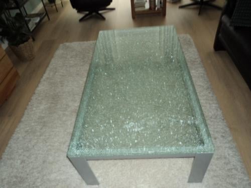 Te koop mooie crash glazen salon tafel met metalen poten grijs