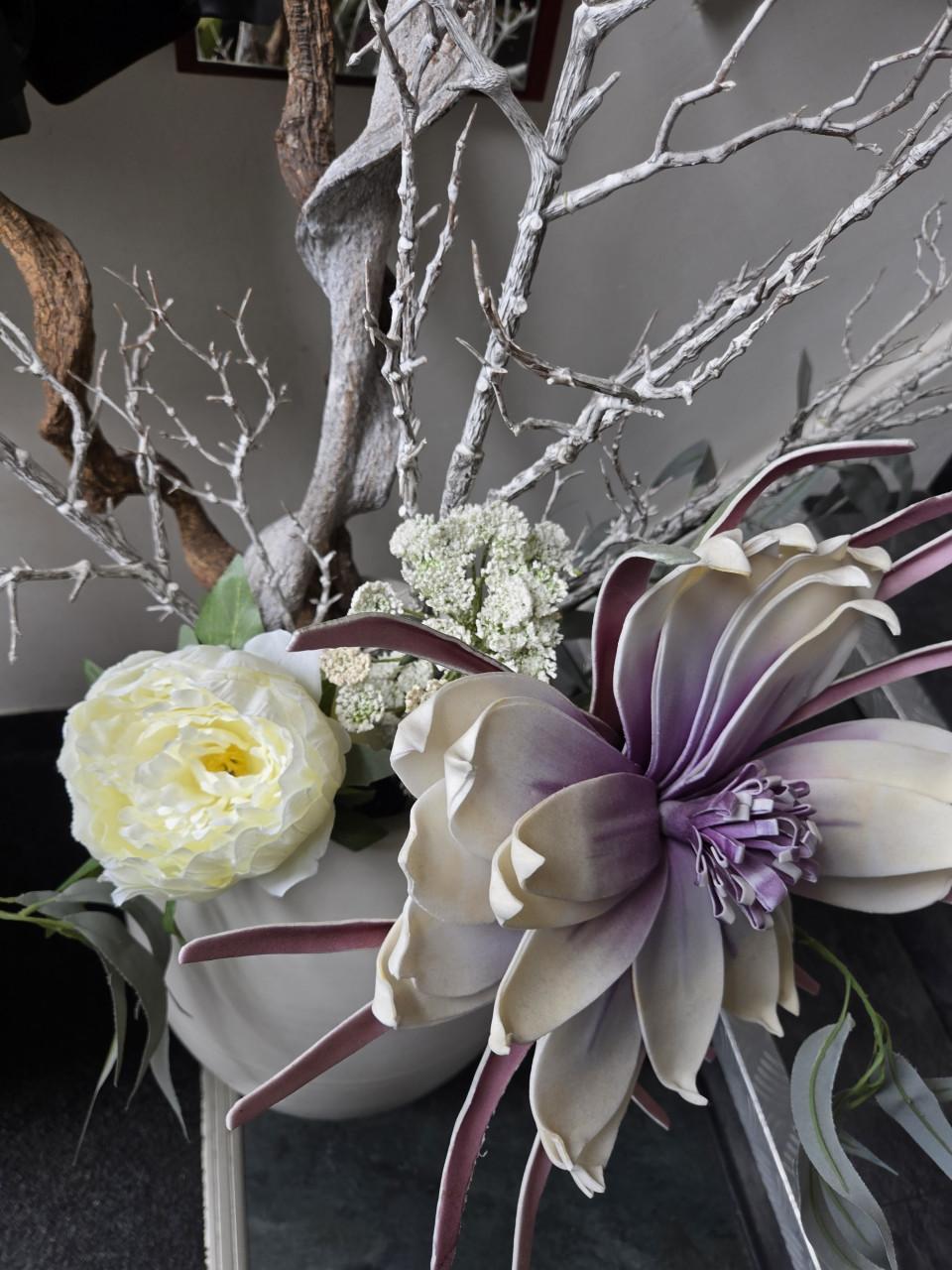 2 grote, witte vazen gevuld met decoratieve kunsttakken en kunstbloemen