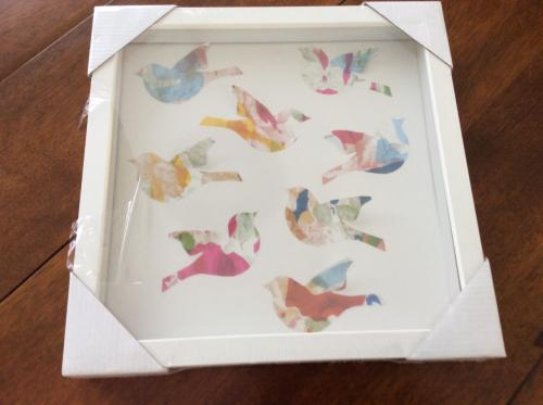 Lijstje met daarin papieren vogeltjes.