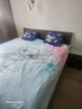 Tweepersoonsbed met electrische lattenbodem ennachtkastje
