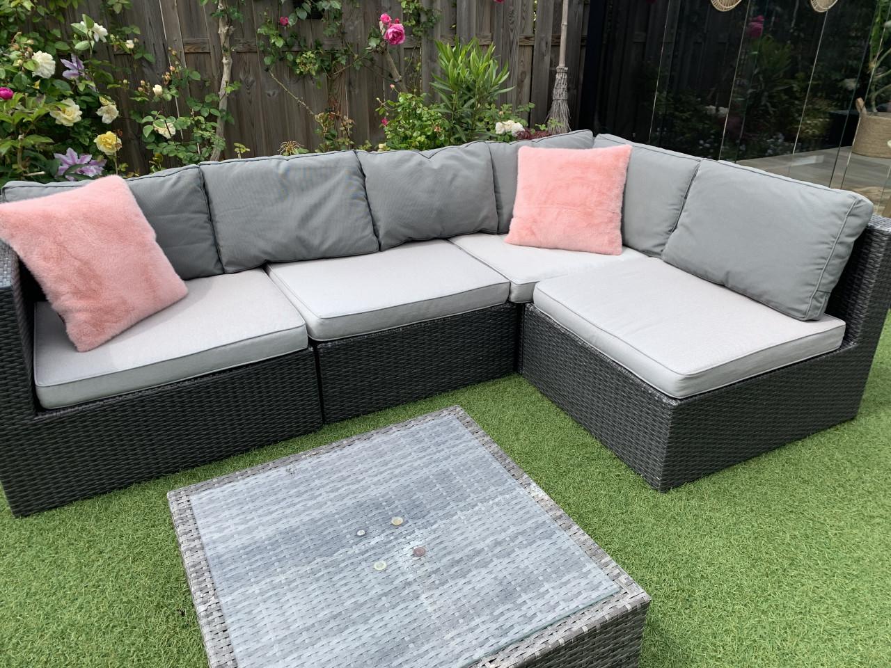 Loungset grijs van Wicker met kussens en tafel.