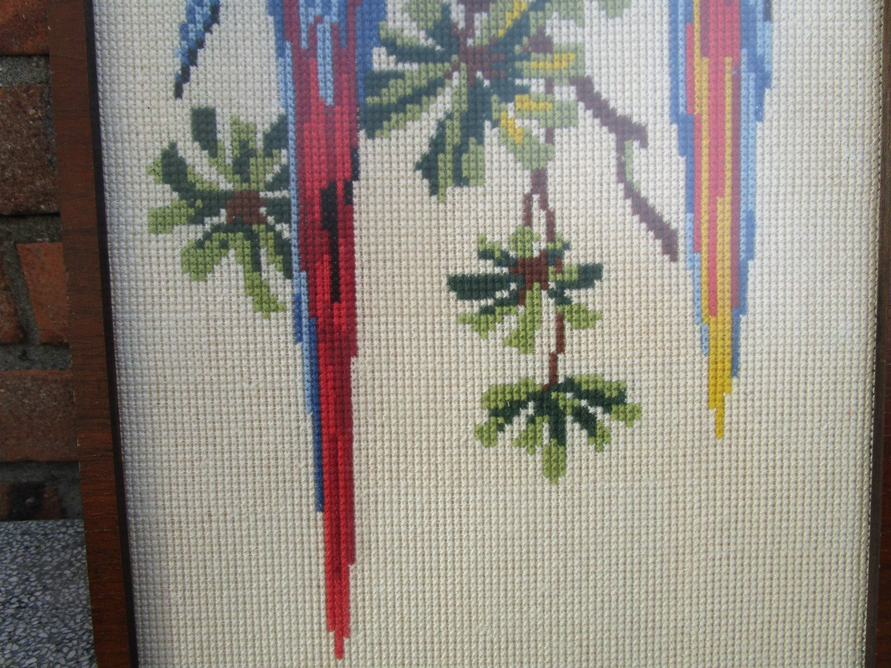 2 geborduurde  papagaaien in gelijst achter ontspiegeld glas. 24 x 48 cm.