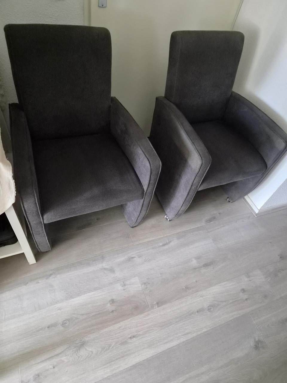 4 grijze stoffen eetkamerstoelen.