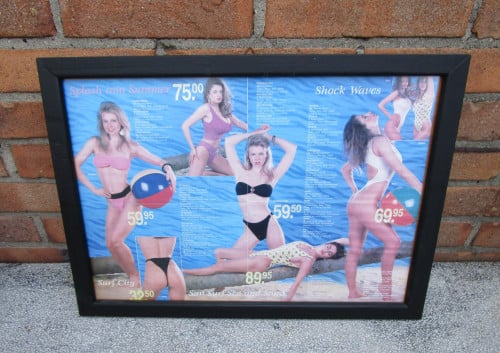Ingelijste folder van dames badkleding achterontspiegelt glas.