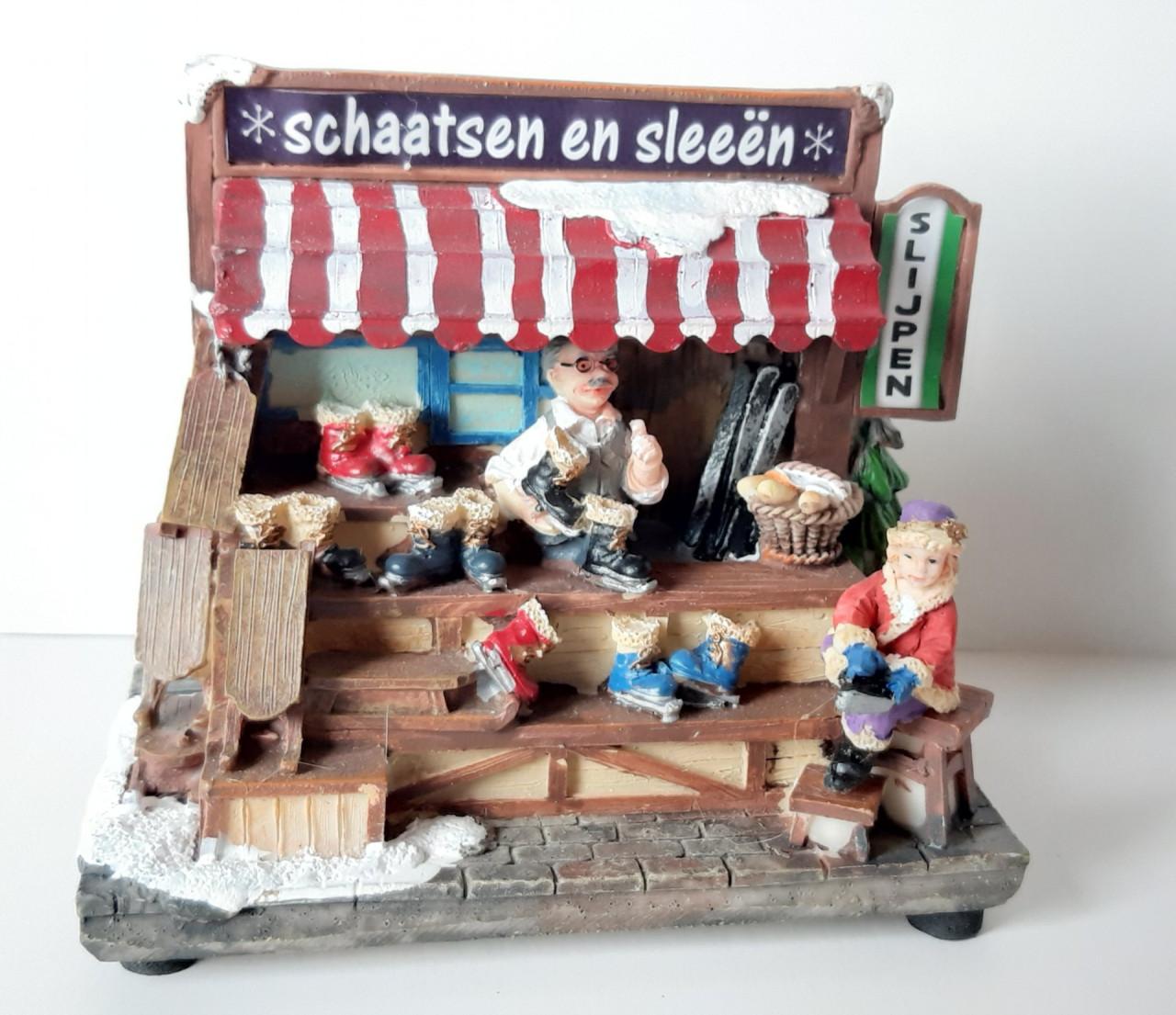 Kersthuisje, kersdecoratie met verlichting, schaatsen en sleeën