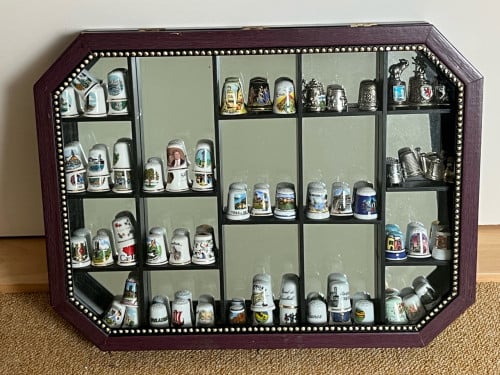 Vitrinekastje met verzameling vingerhoedjes