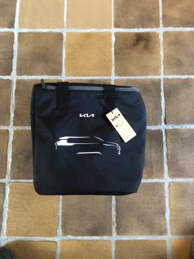 Nieuwe Kia tas met een dekentje en een beker en een sleutel hanger.