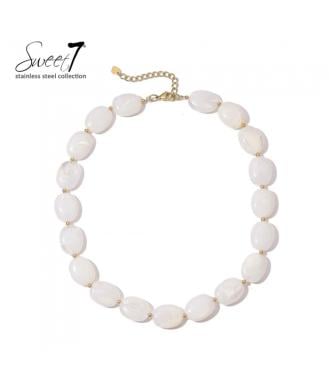 Halsketting met witte kralen en gouden details, elegant en modern.