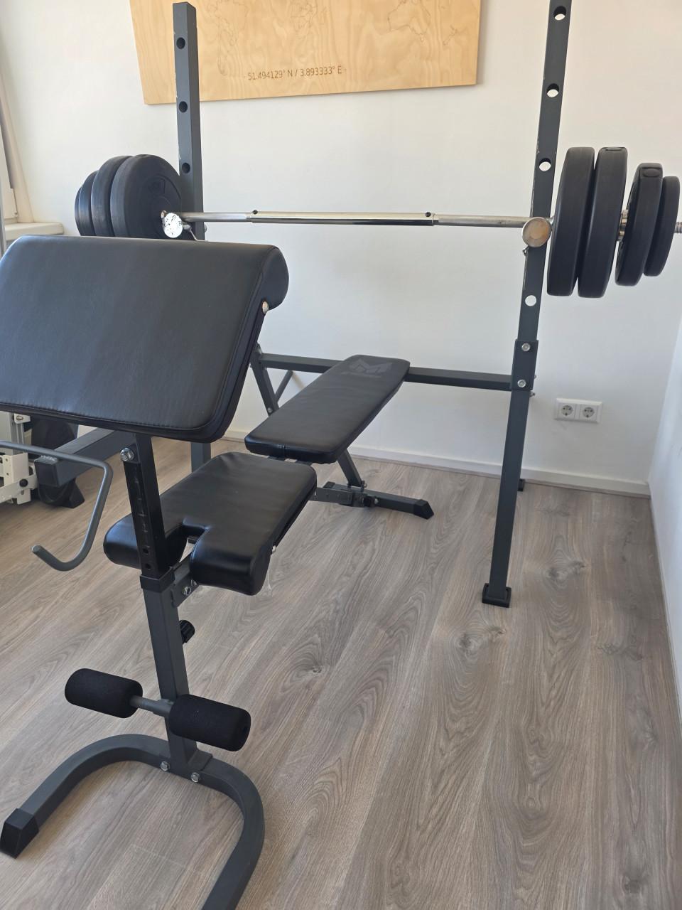 Fitnessbank met halterstang en gewichten