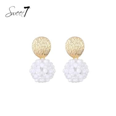 Oorbellen met goudkleurige schijf en witte kralenbol.