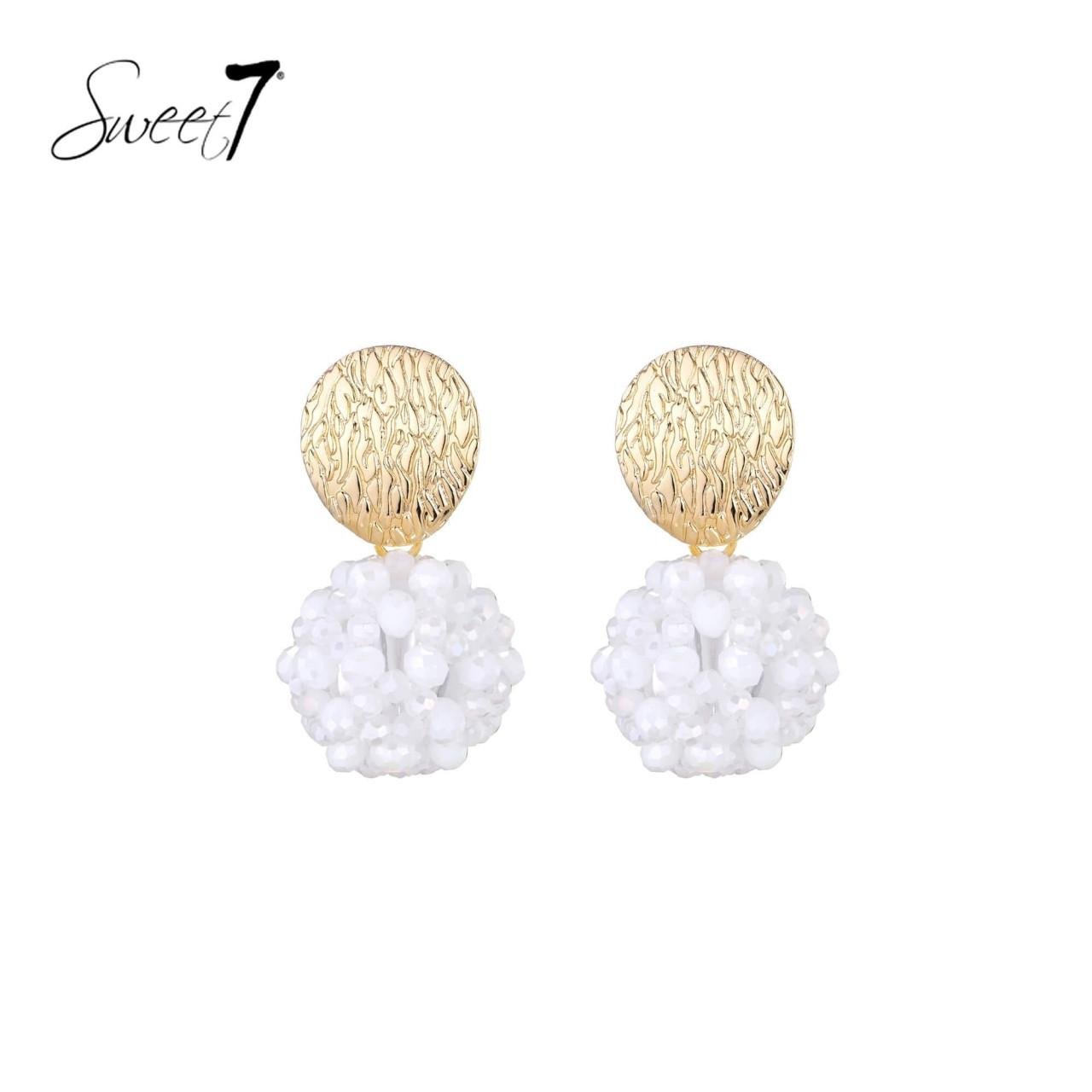 Oorbellen met goudkleurige schijf en witte kralenbol.