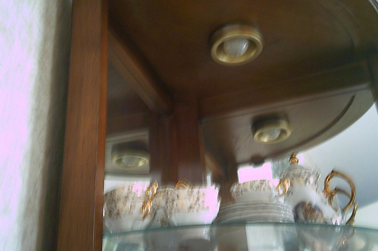 HOEKVITRINE in ronde vorm met spiegelwanden en verlichting.