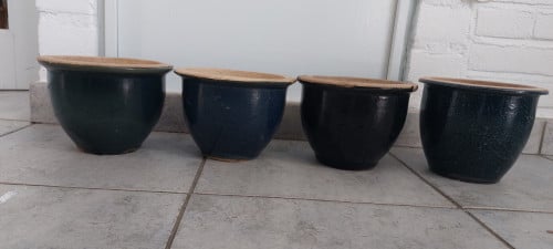 Vier blauwe stenen potten voor in de tuin