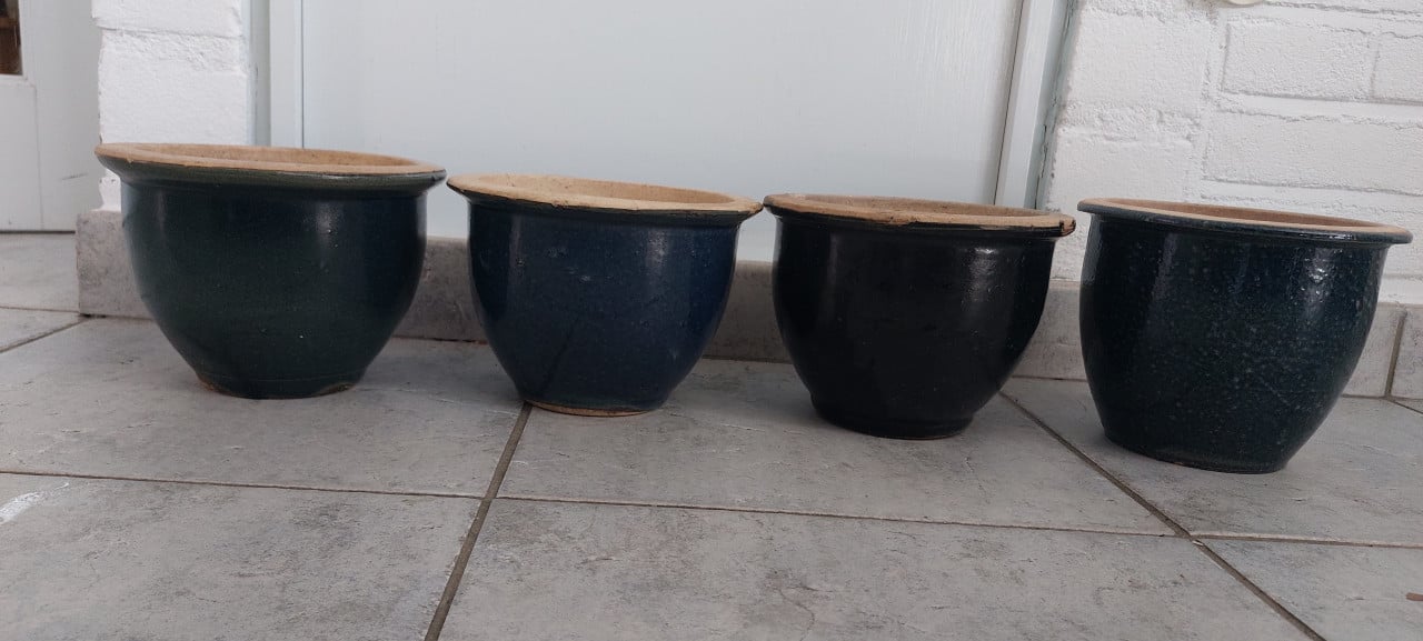 Vier blauwe stenen potten voor in de tuin
