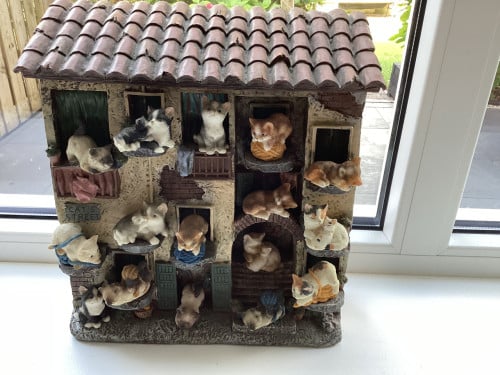 Stenen kattenluik met katten beeldjes