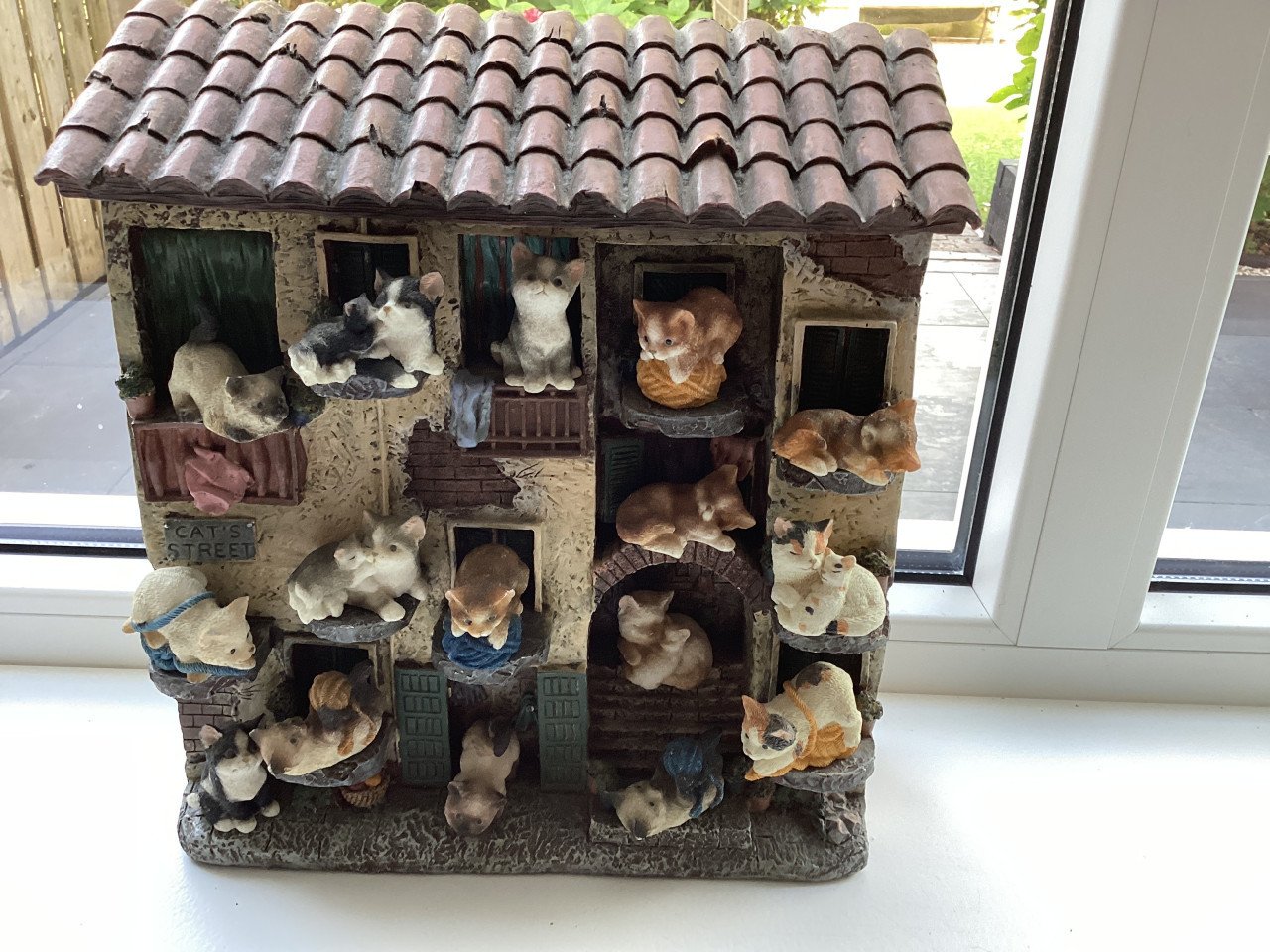 Stenen kattenluik met katten beeldjes