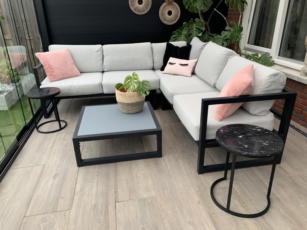 Zwart aluminium loungeset, met kussens en tafel.