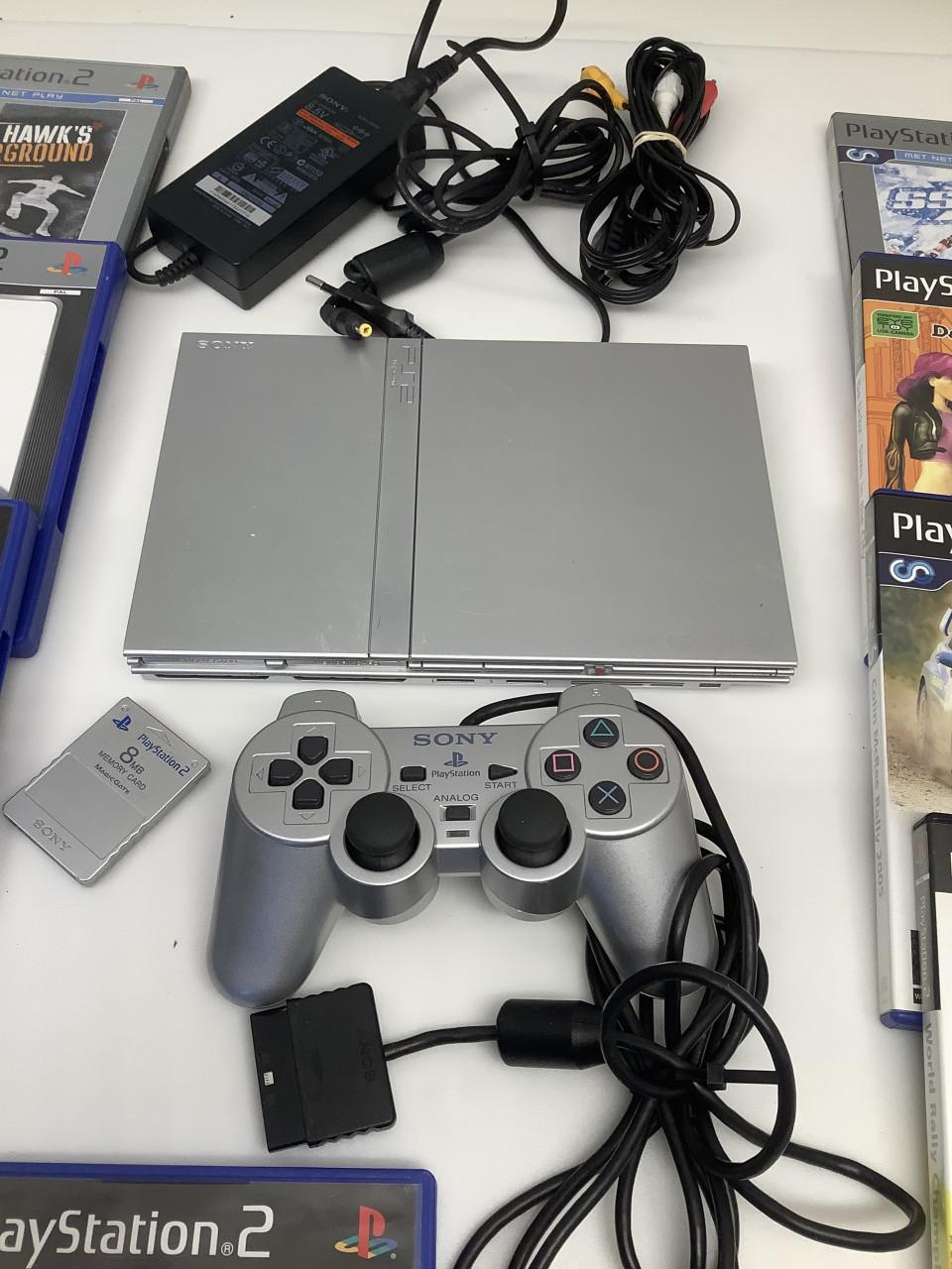 PlayStation 2 zilverkleurig met controller, memory card en spellen.