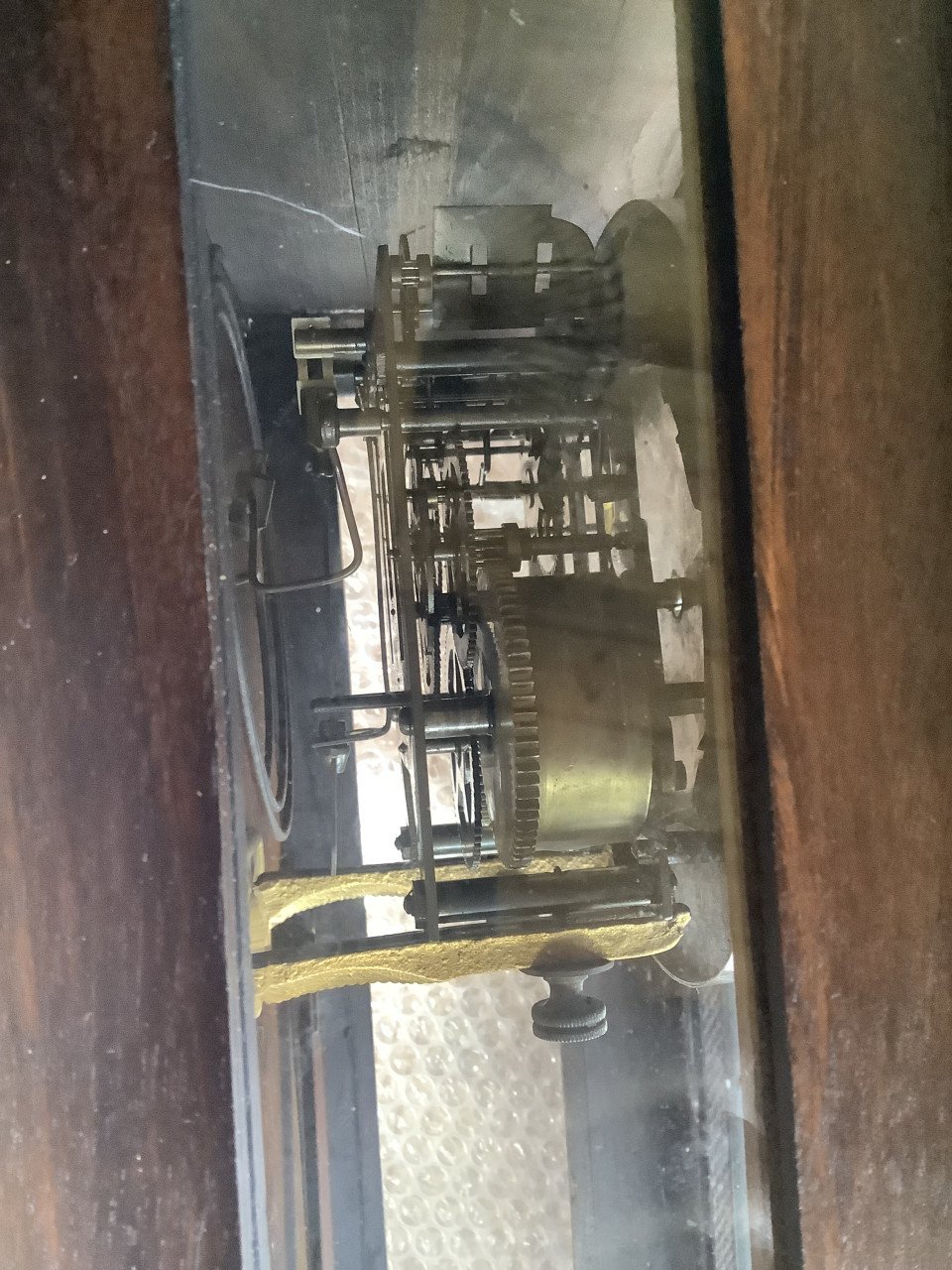 Oude, vintage hangklok met slinger en sleutel.